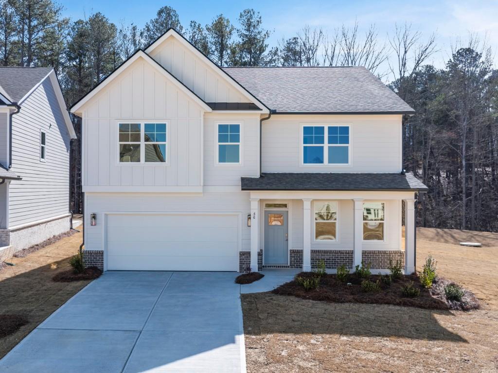 a view of a white house with large windows next to a yard