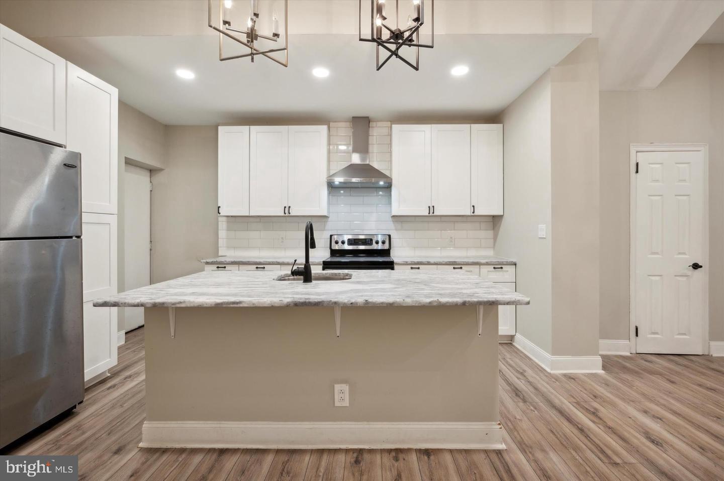 2021 North 33rd Street, Unit 1 Philadelphia, PA 19121 - Photo 9 of 21 a kitchen with kitchen island stainless steel appliances a stove refrigerator and cabinets