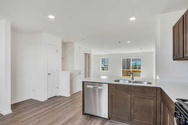 a kitchen with stainless steel appliances granite countertop a sink and dishwasher with wooden floor
