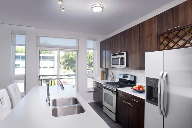 a kitchen with stainless steel appliances granite countertop a refrigerator and a stove top oven