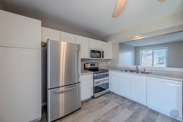 a kitchen with stainless steel appliances a refrigerator sink and microwave