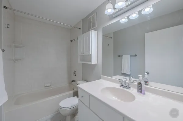 a bathroom with a sink toilet vanity and shower