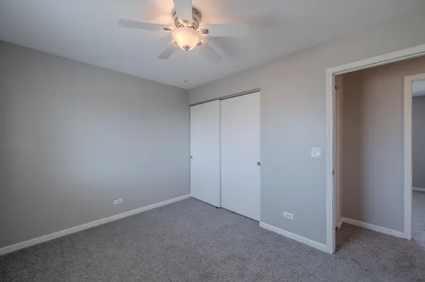 an empty room with a ceiling fan and a fan