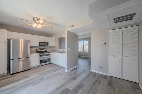 a kitchen with stainless steel appliances kitchen island granite countertop a refrigerator and a stove top oven