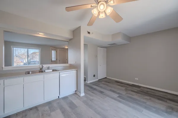 a view of a kitchen with a sink dishwasher a kitchen island with wooden floor