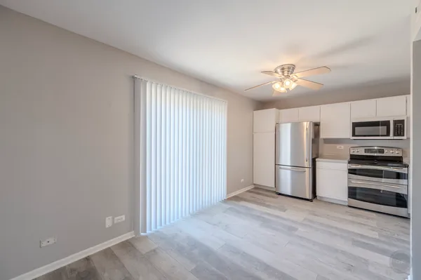an empty room with a kitchen and stainless steel appliances
