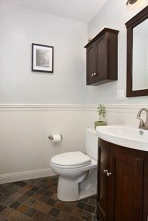 a bathroom with a toilet sink and mirror