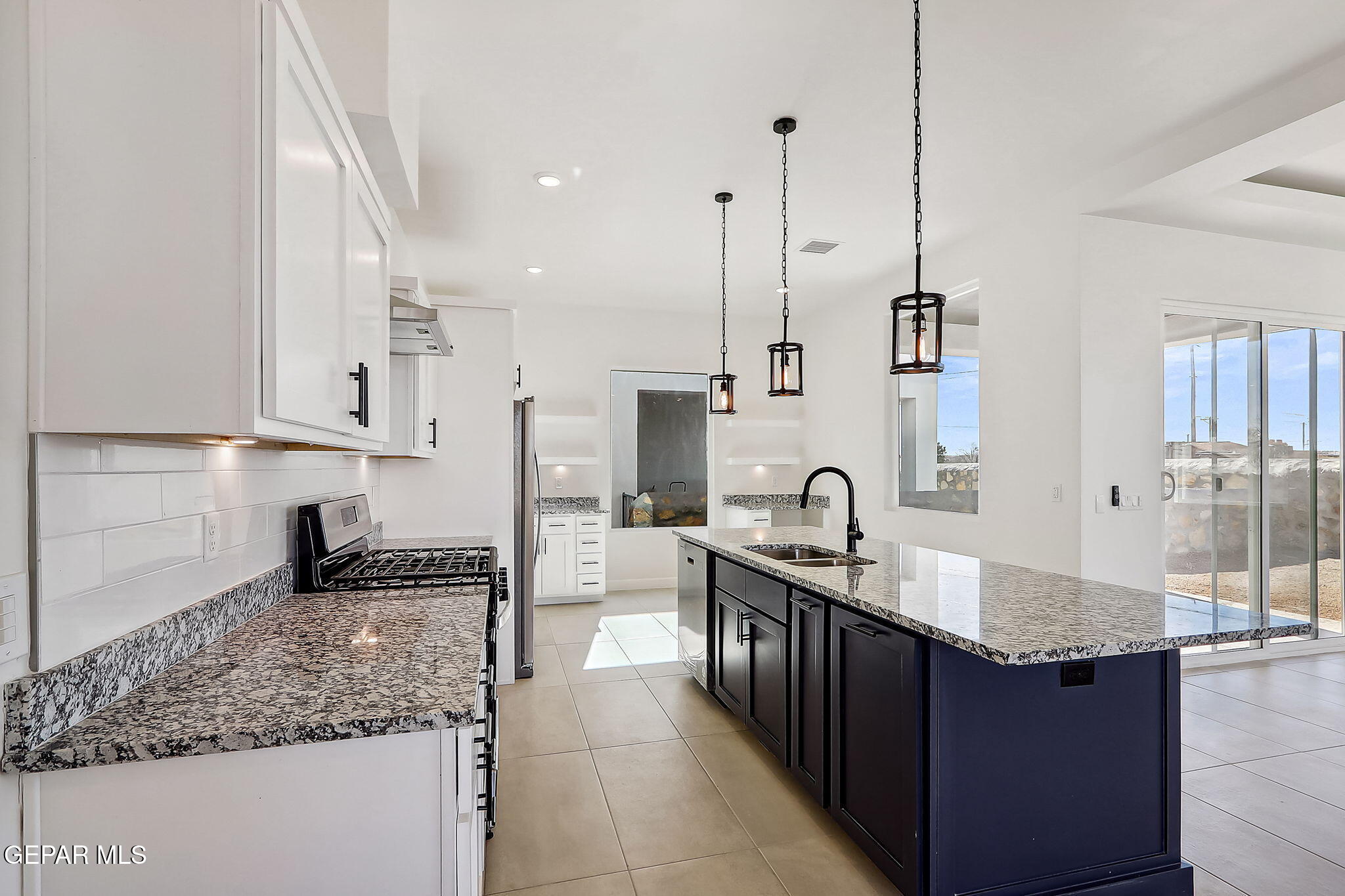 5997 Ruidoso Downs Street El Paso, TX 79932 - Photo 15 of 42 a kitchen with stainless steel appliances granite countertop a sink a stove and a wooden floor
