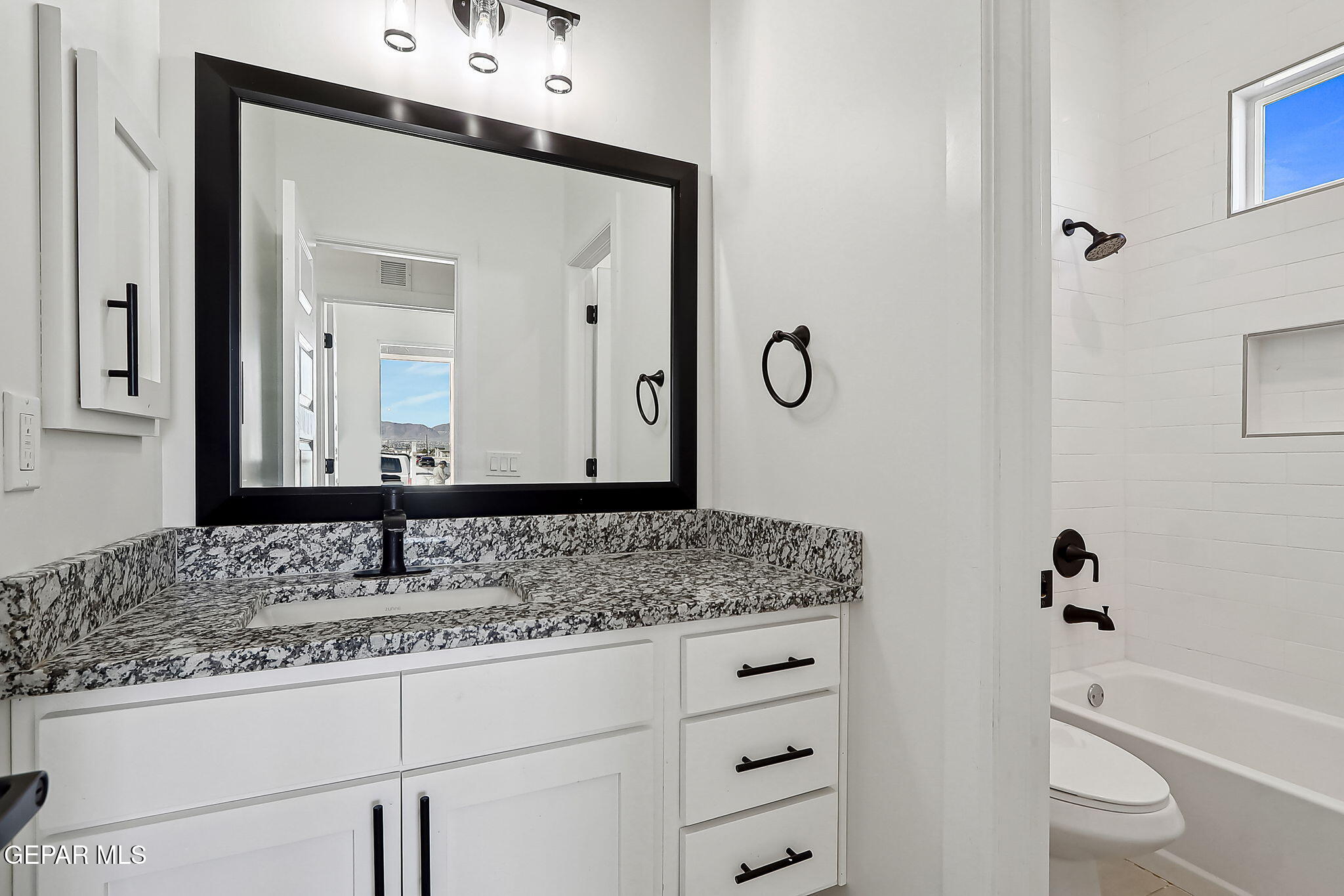 5997 Ruidoso Downs Street El Paso, TX 79932 - Photo 18 of 42 a bathroom with a granite countertop sink and a mirror