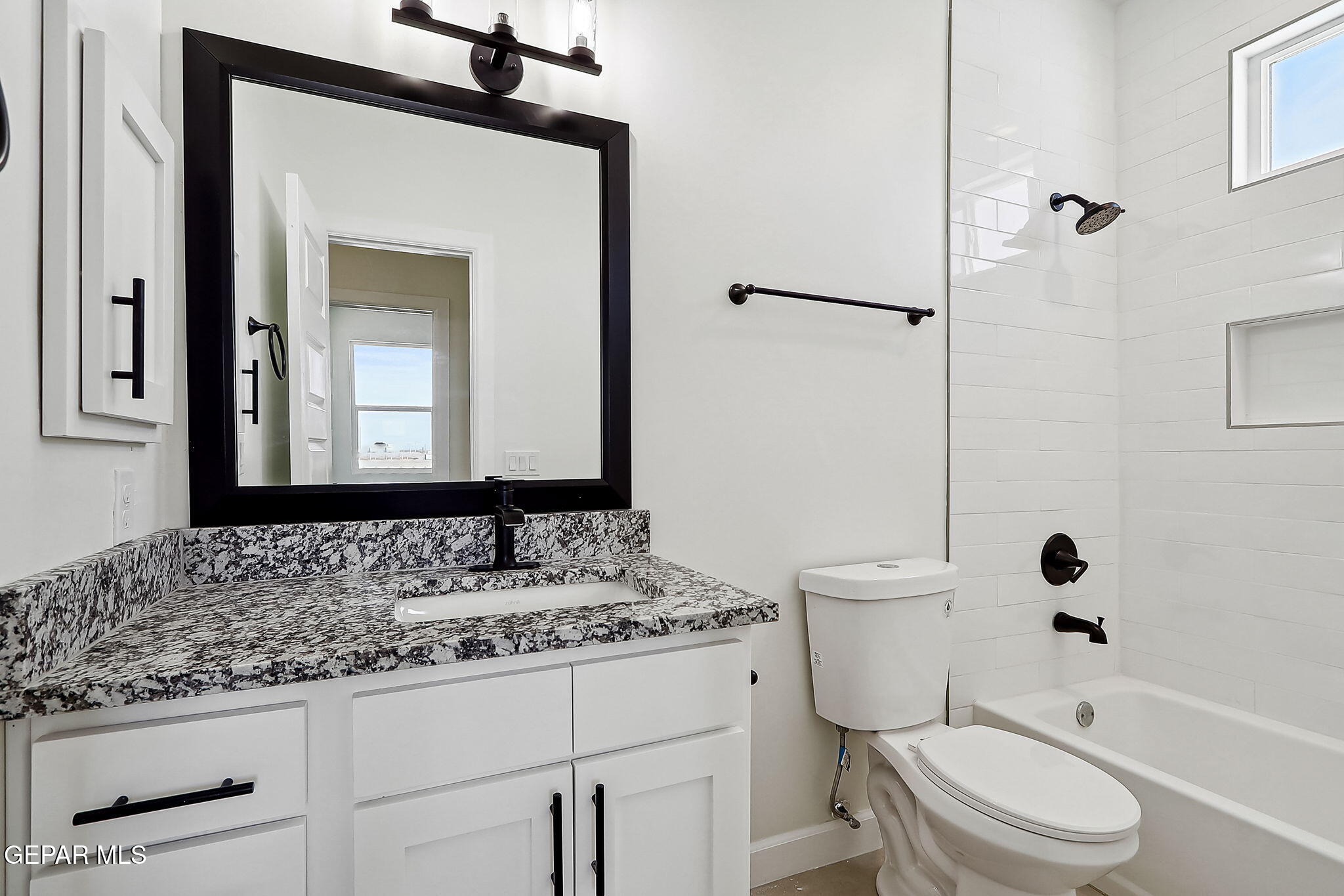 5997 Ruidoso Downs Street El Paso, TX 79932 - Photo 20 of 42 a bathroom with a granite countertop toilet a sink and a mirror