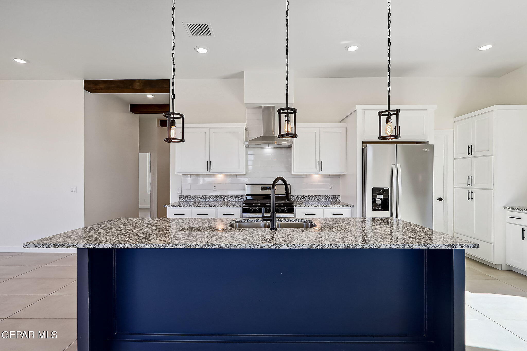 5997 Ruidoso Downs Street El Paso, TX 79932 - Photo 3 of 42 a kitchen with kitchen island granite countertop a sink a counter space stainless steel appliances and cabinets