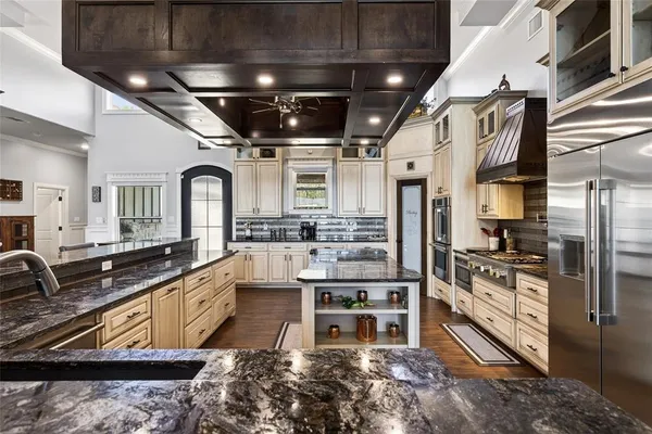 a kitchen with stainless steel appliances a kitchen island hardwood floor and a sink