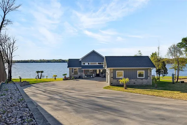 a view of a house with a big yard and large trees