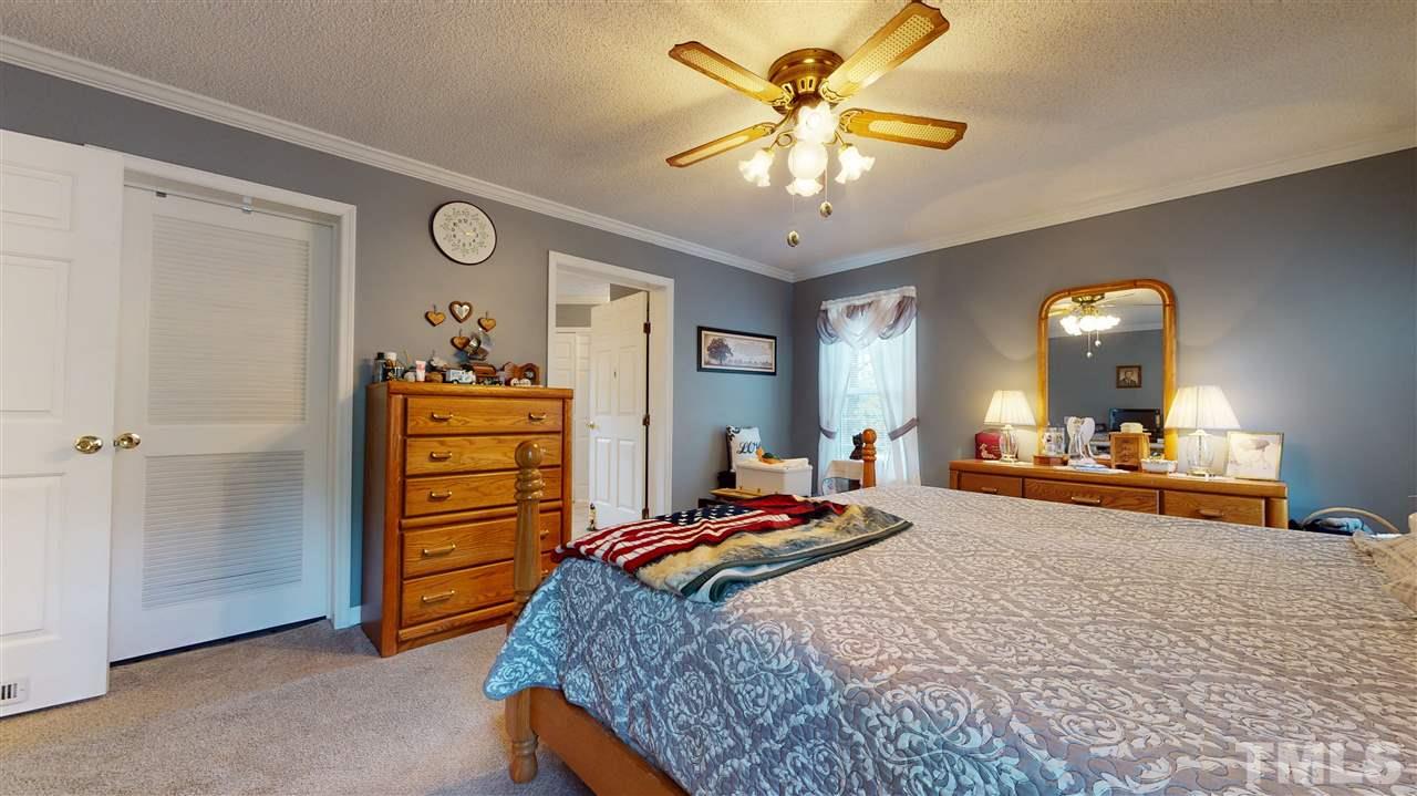395 Woodys Store Road Roxboro, NC 27574 - Photo 22 of 30 a bedroom with a bed and a chandelier
