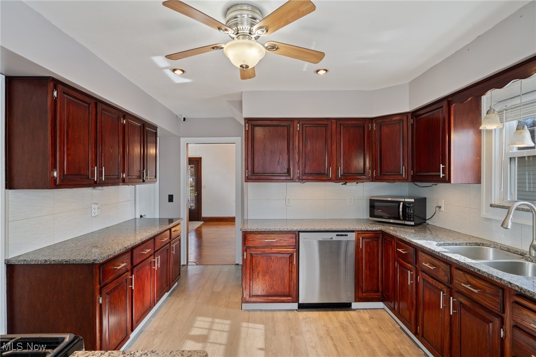 26903 Butternut Ridge Road North Olmsted, OH 44070 - Photo 11 of 37 Kitchen featuring light wood-style flooring, stainless steel appliances, dark brown cabinets, a ceiling fan, and a sink