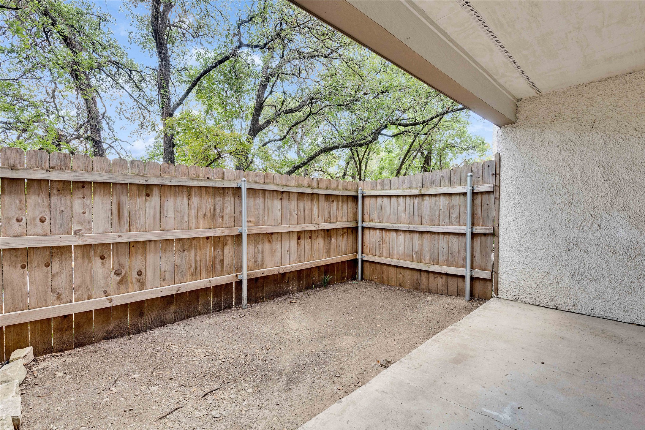 6910 Hart Lane, Unit 403 Austin, TX 78731 - Photo 18 of 20 a view of backyard with large trees and wooden fence