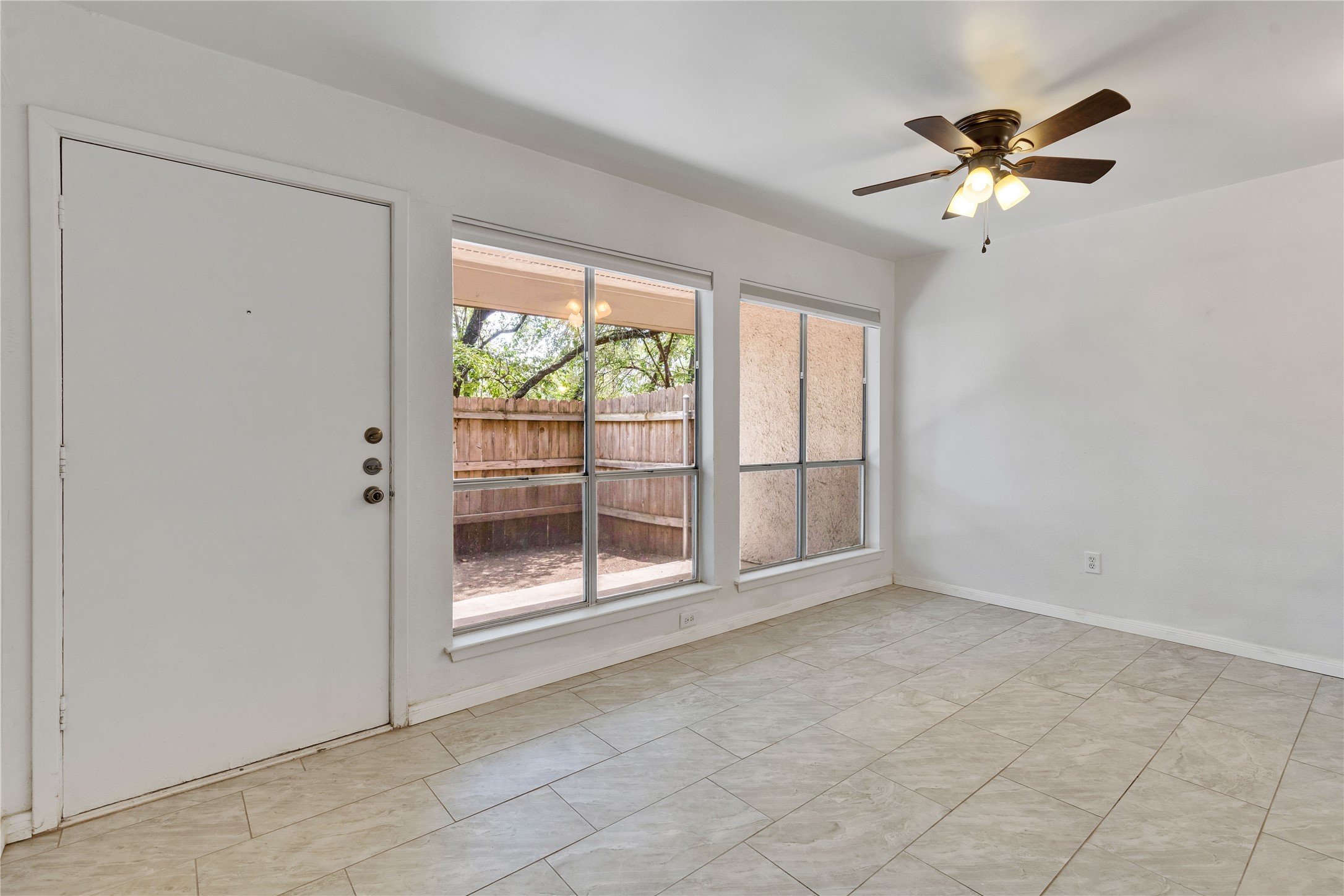 6910 Hart Lane, Unit 403 Austin, TX 78731 - Photo 4 of 20 an empty room with windows and ceiling fan