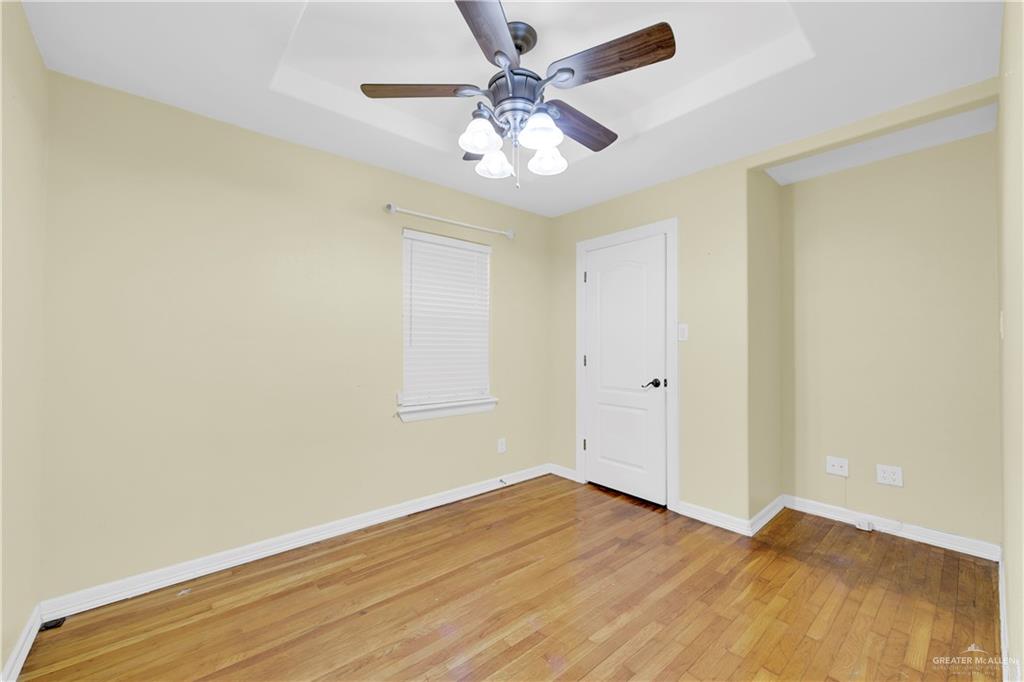 1815 Thornton Street Mission, TX 78572 - Photo 17 of 27 Empty room with light wood-style floors, a raised ceiling, and ceiling fan