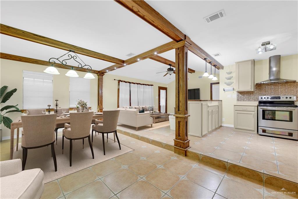1815 Thornton Street Mission, TX 78572 - Photo 26 of 27 Kitchen with decorative light fixtures, electric stove, open floor plan, wall chimney range hood, and light tile patterned flooring