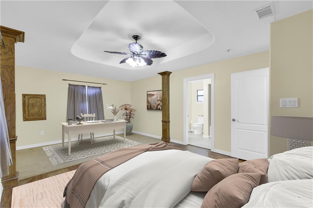 1815 Thornton Street Mission, TX 78572 - Photo 6 of 27 Bedroom featuring ceiling fan, a tray ceiling, wood finished floors, and connected bathroom