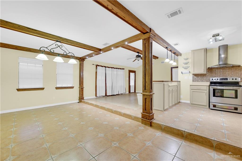 1815 Thornton Street Mission, TX 78572 - Photo 27 of 27 Kitchen with hanging light fixtures, electric range, wall chimney range hood, open floor plan, and light tile patterned floors