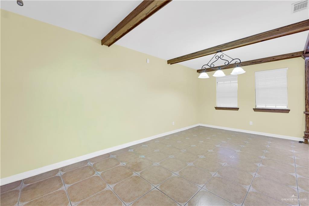 1815 Thornton Street Mission, TX 78572 - Photo 7 of 27 Tiled empty room featuring baseboards and beam ceiling