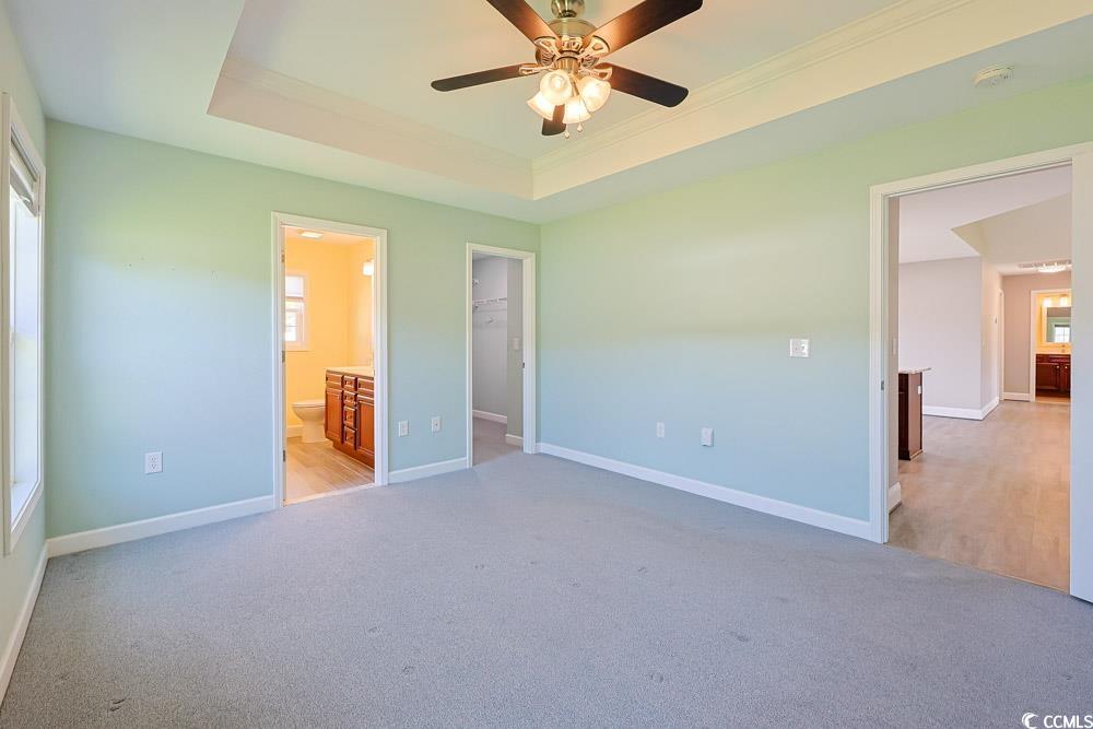 1036 Macala Drive Conway, SC 29527 - Photo 12 of 34 Unfurnished bedroom featuring a raised ceiling, a walk in closet, light carpet, and crown molding