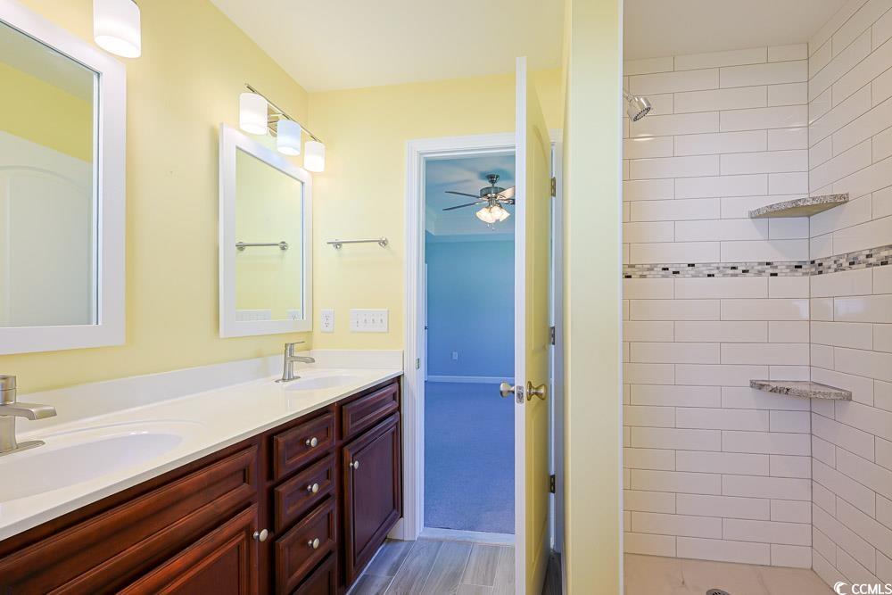 1036 Macala Drive Conway, SC 29527 - Photo 13 of 34 Full bath featuring double vanity, tiled shower, light wood-type flooring, and a ceiling fan
