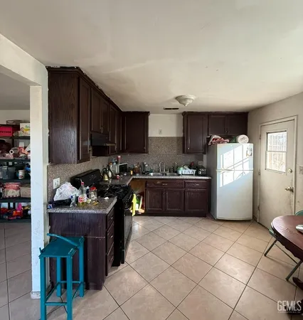 a kitchen with stainless steel appliances a stove a sink a refrigerator and cabinets
