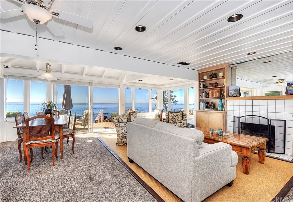 Living/dining area opens to multiple decks, ocean views, and steps to the beach.