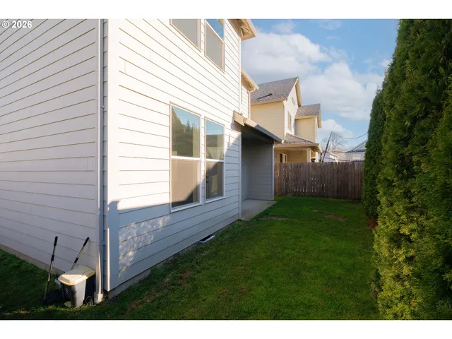 a view of backyard with barbeque grill and wooden fence