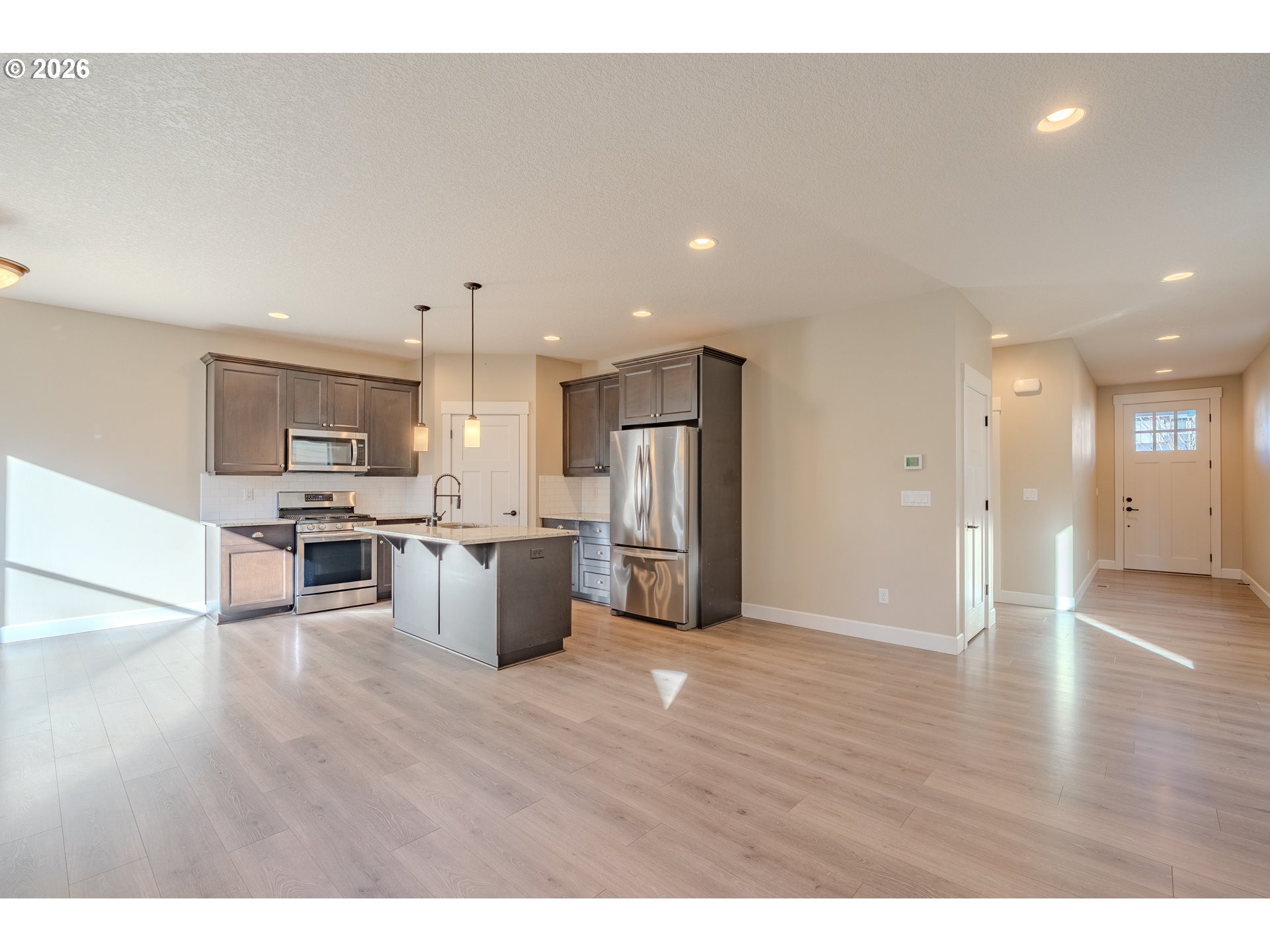 1145 South Quail Run Place Ridgefield, WA 98642 - Photo 6 of 41 a kitchen with stainless steel appliances kitchen island wooden cabinets and granite counter tops