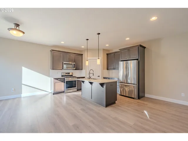 a kitchen with stainless steel appliances a refrigerator and a stove top oven