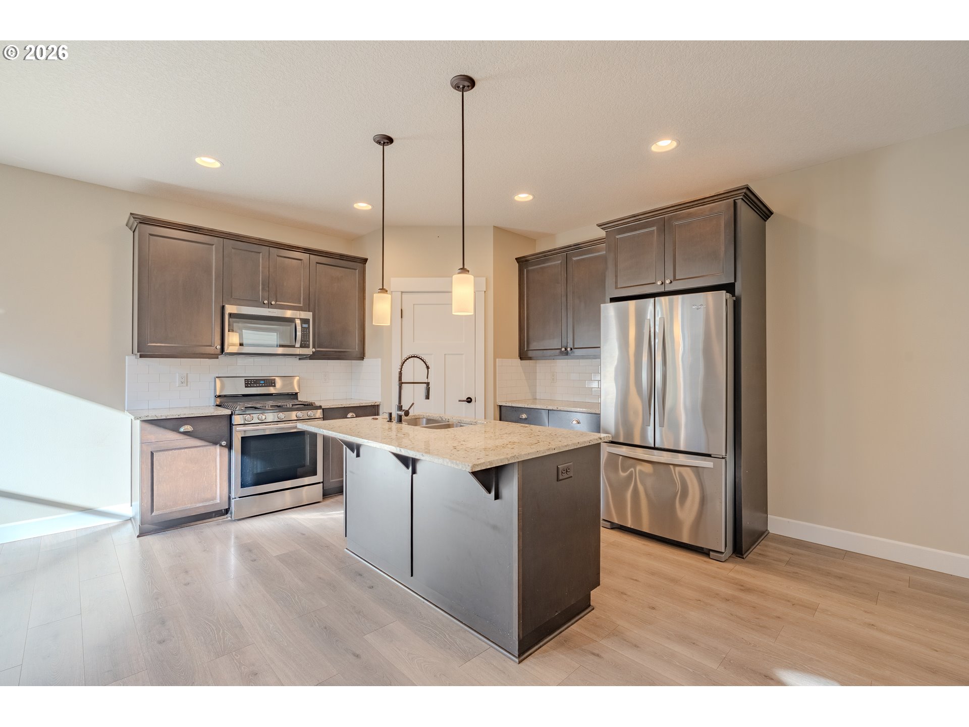 1145 South Quail Run Place Ridgefield, WA 98642 - Photo 8 of 41 a kitchen with stainless steel appliances granite countertop a refrigerator a sink dishwasher a stove with white cabinets