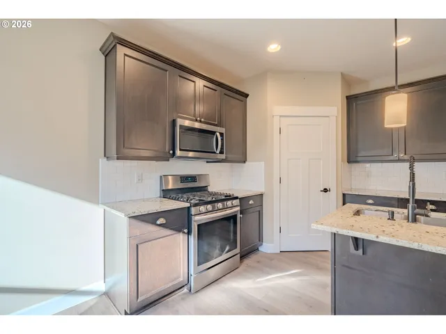 a kitchen with a sink stove and microwave