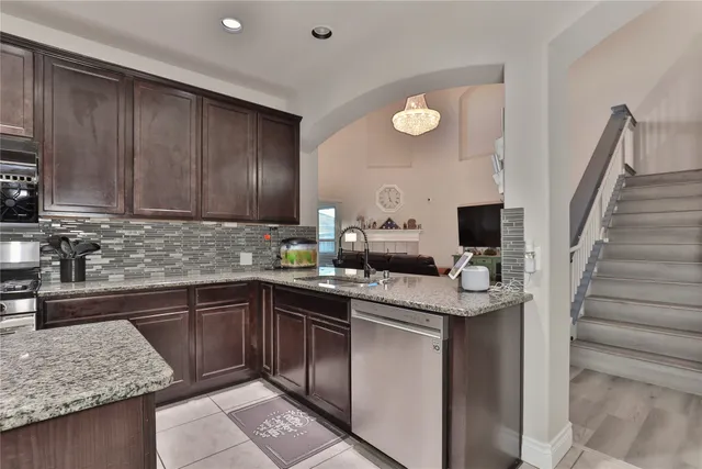 a kitchen with stainless steel appliances granite countertop a sink stove and cabinets