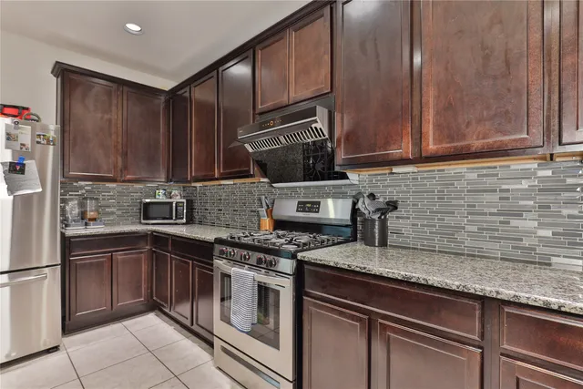 a kitchen with granite countertop a sink stainless steel appliances and cabinets