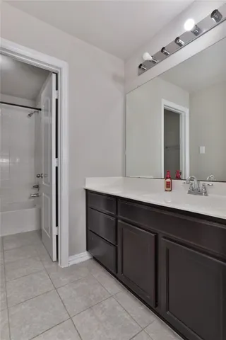 a bathroom with a tub sink shower and mirror