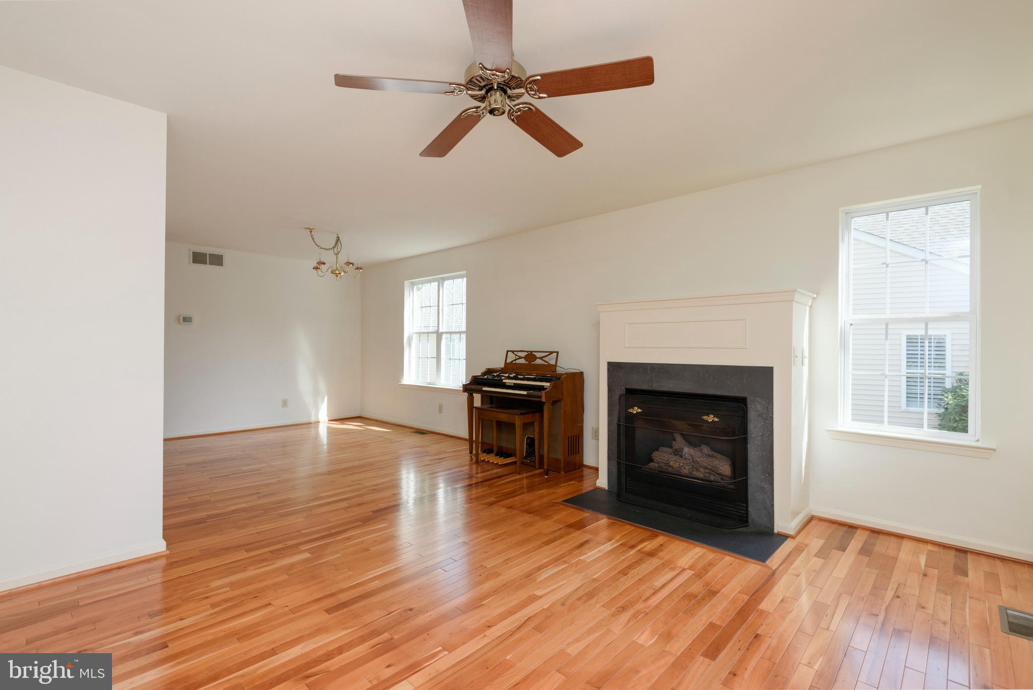 403 East Glenview Drive West Grove, PA 19390 - Photo 4 of 25 an empty room with wooden floor fireplace and windows
