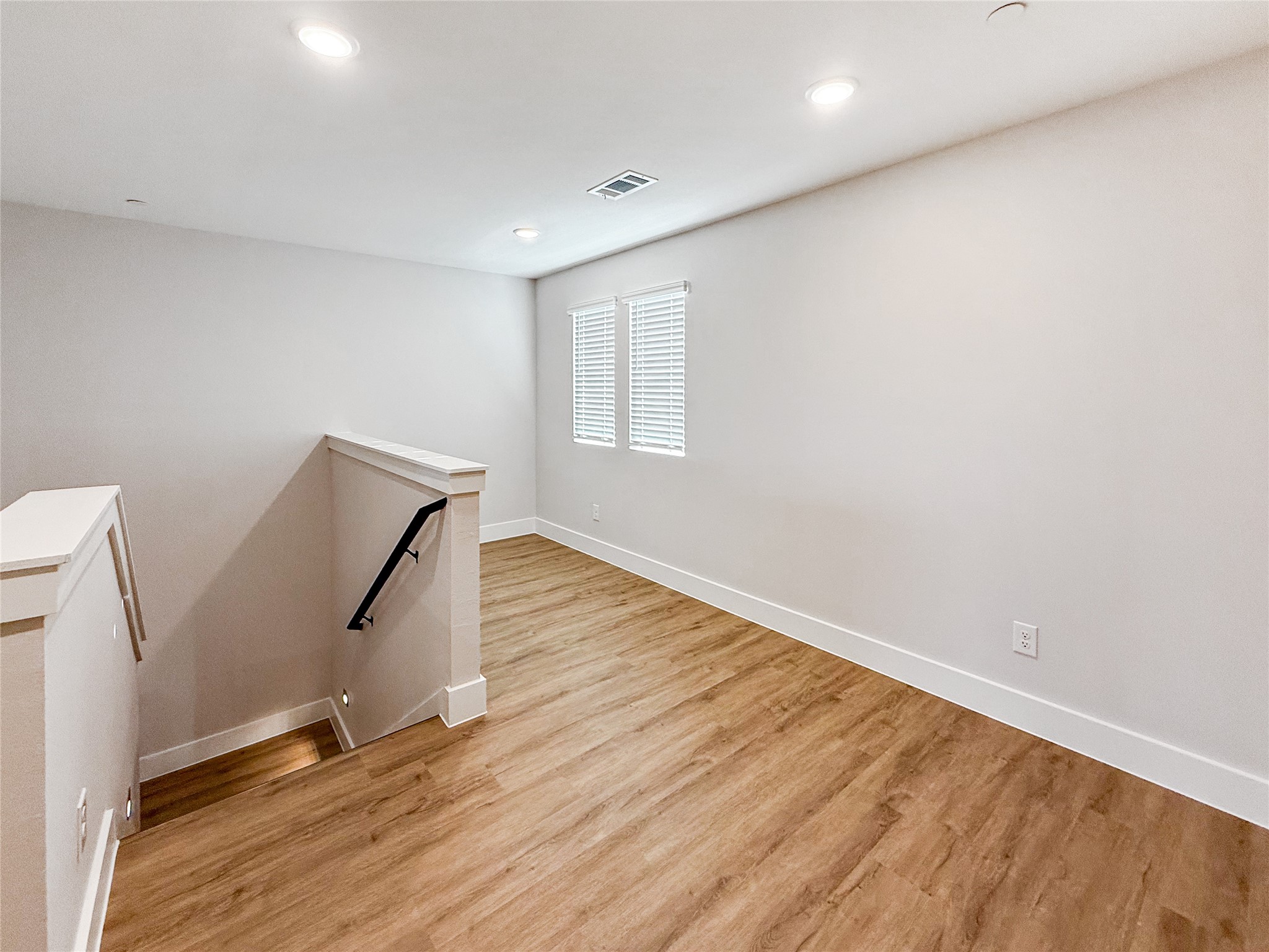 5601 Mobeetie Loop Bee Cave, TX 78738 - Photo 13 of 23 an empty room with wooden floor and white walls