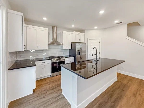 a kitchen with stainless steel appliances granite countertop a sink stove and refrigerator