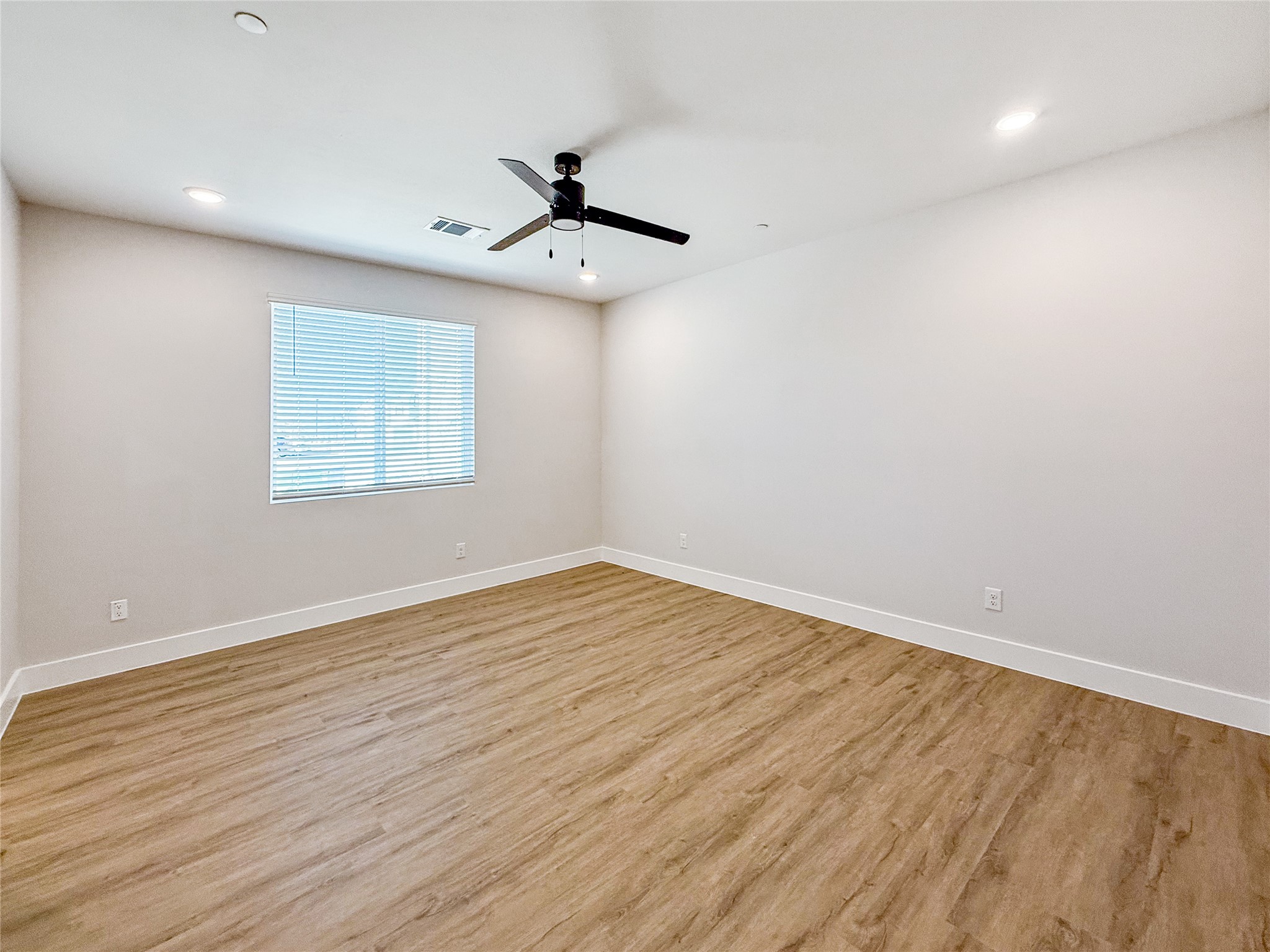 5601 Mobeetie Loop Bee Cave, TX 78738 - Photo 8 of 23 an empty room with wooden floor fan and windows
