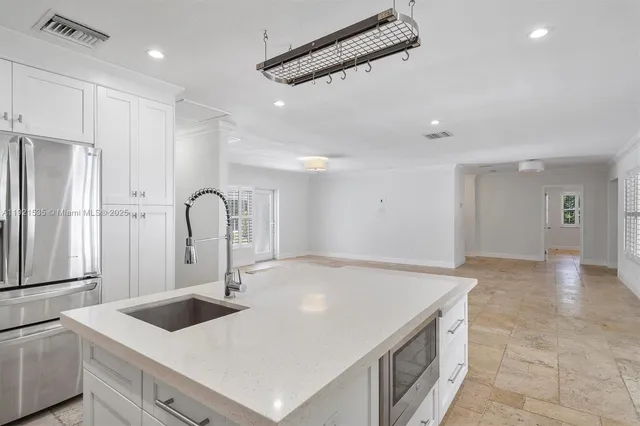 a kitchen with a sink a counter top space and stainless steel appliances