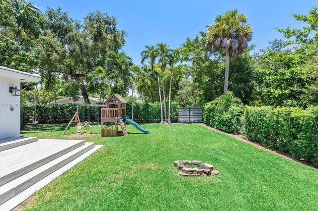 a view of a backyard with a slide trees