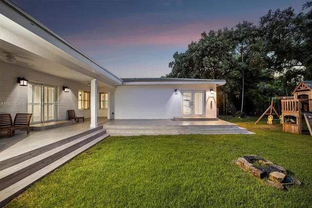 a view of a house with backyard and sitting area