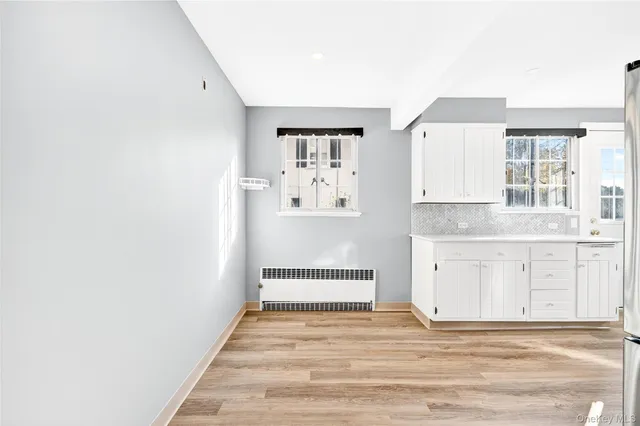 a view of a hallway with wooden floor and a large window