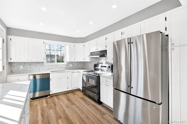 a kitchen with stainless steel appliances a refrigerator sink and microwave