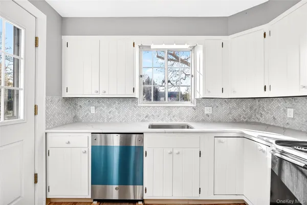 a kitchen with granite countertop white cabinets and white appliances