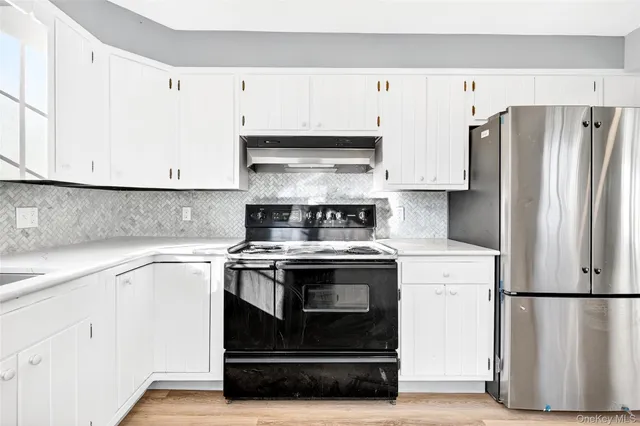 a kitchen with white cabinets and white stainless steel appliances and refrigerator