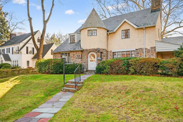 a view of a big house with a big yard and large trees